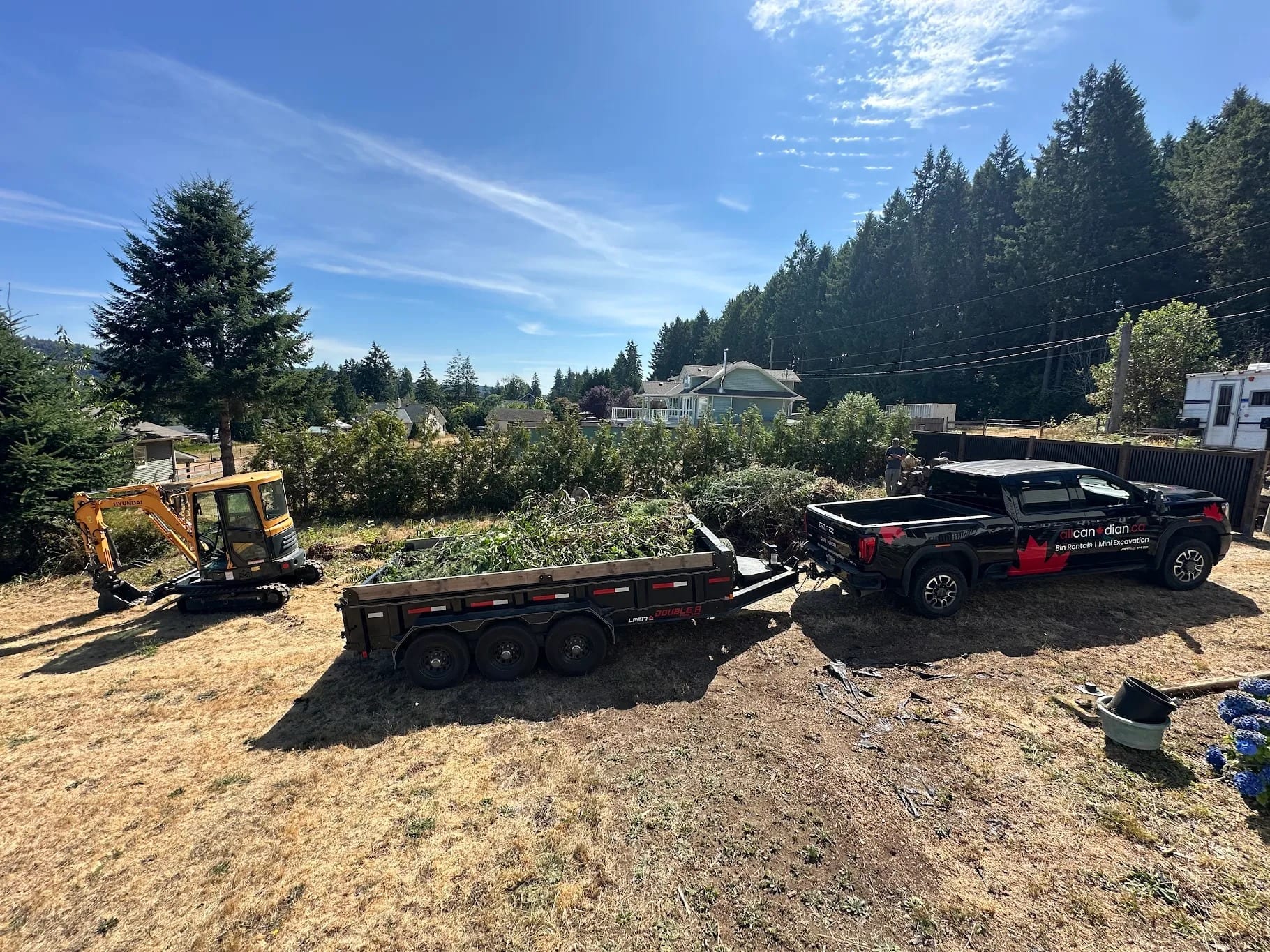 Mini excavator on a freshly cleared property. Land clearing on Vancouver Island
