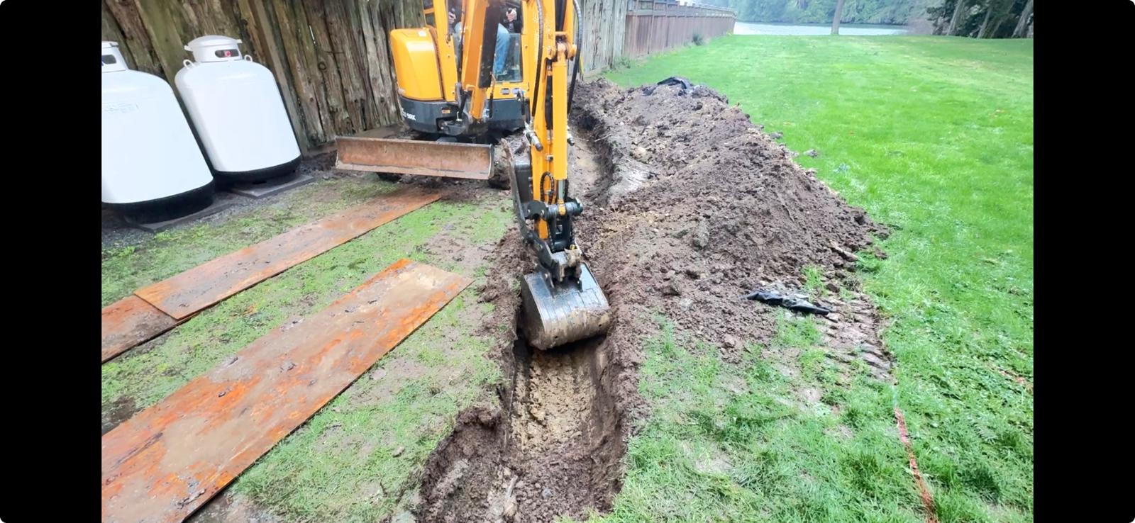 Mini excavator trenching on a residential job in Central Vancouver Island